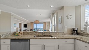 A kitchen with granite countertops, a dishwasher, and a coffee maker. - Seachase 905w (Orange Beach)