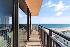A balcony with a view of the beach, a chair, and a railing. - Seachase 905w (Orange Beach)