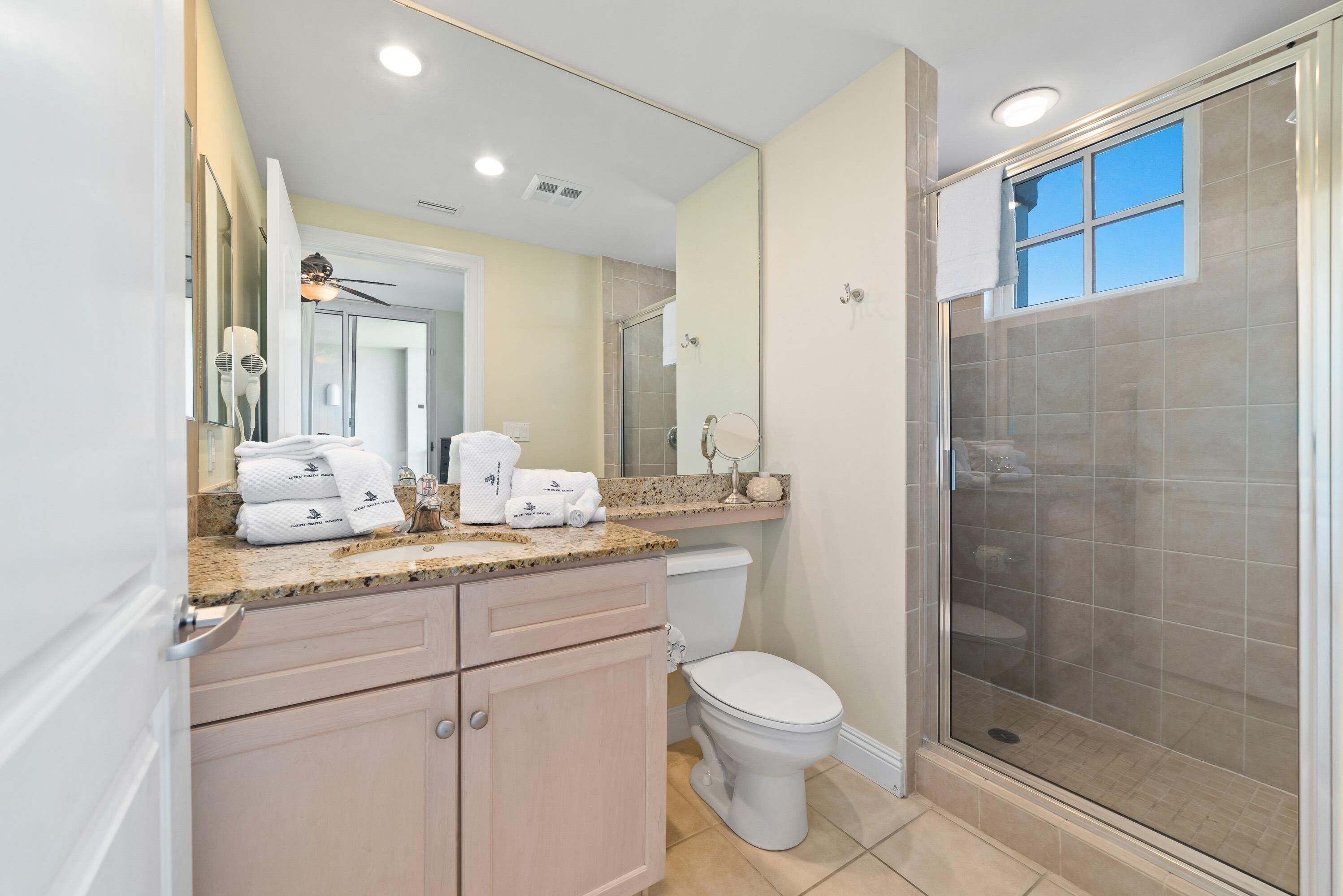 Une salle de bain moderne équipée d’une douche, de toilettes et d’un meuble-lavabo.