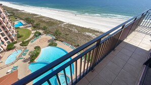 A resort with a large pool, a beach, and a view of the ocean.