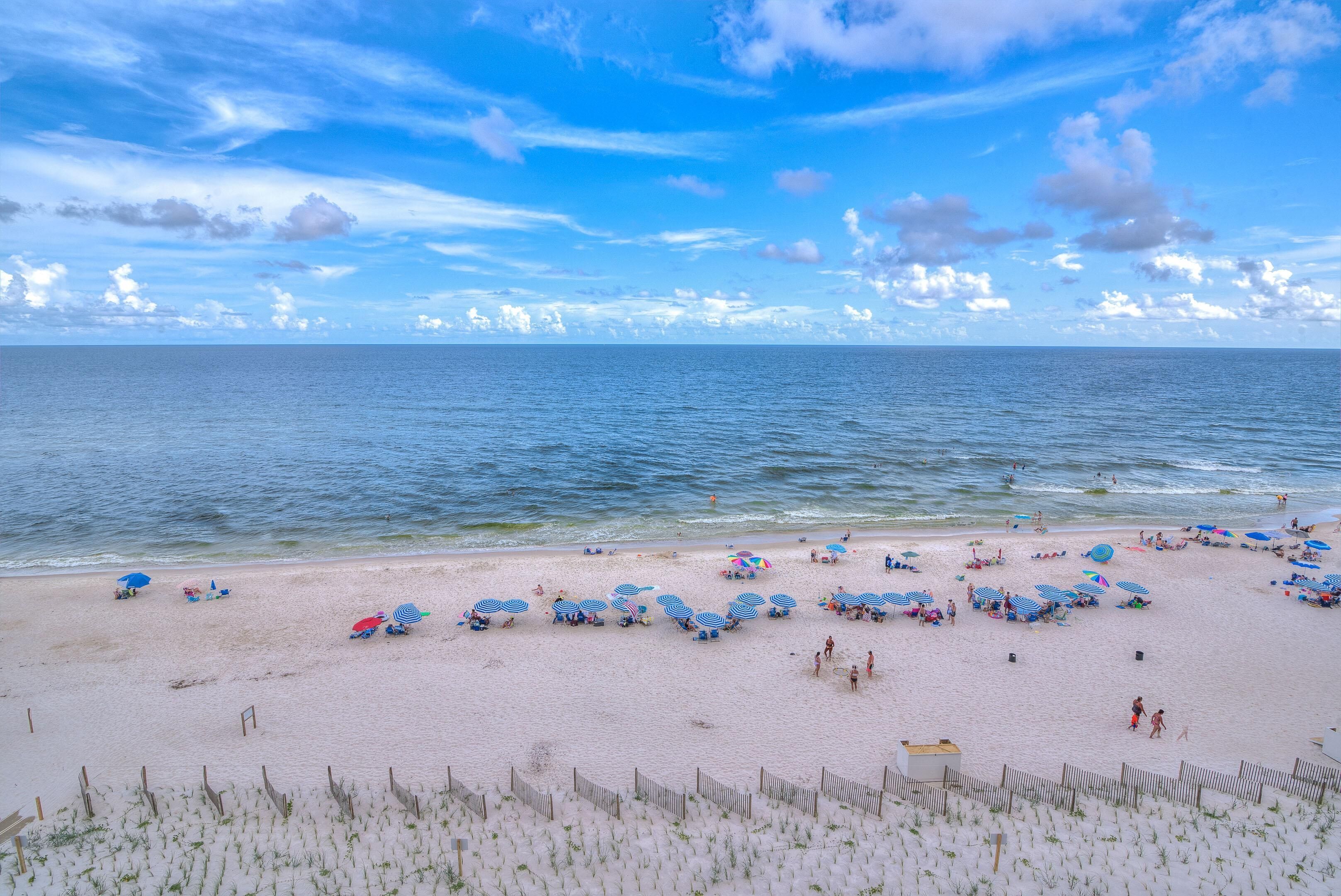A beach with umbrellas and people.