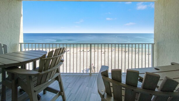 A balcony with wooden furniture overlooking a beach. - Perdido Skye 65 (Pensacola)