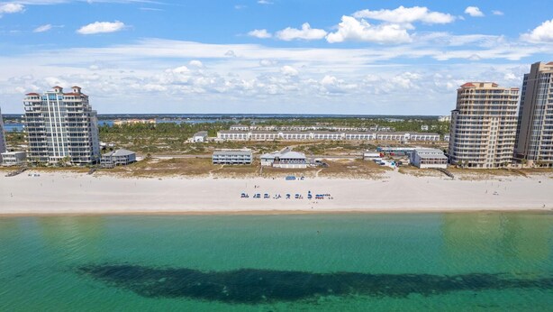 A beachfront hotel with multiple high-rise buildings, a sandy beach, and a clear view of the ocean. - Lost Key A505 (Pensacola)
