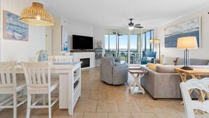 A spacious living area with a dining table, chairs, a sofa, and a television. - Lost Key A505 (Pensacola)