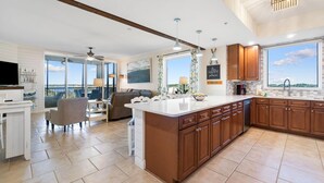 A spacious kitchen with a large island, wooden cabinets, and a view to the outside. - Lost Key A505 (Pensacola)
