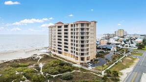 A multi-story hotel with balconies, located near a beach and ocean. - Vista Del Mar 402 (Pensacola)