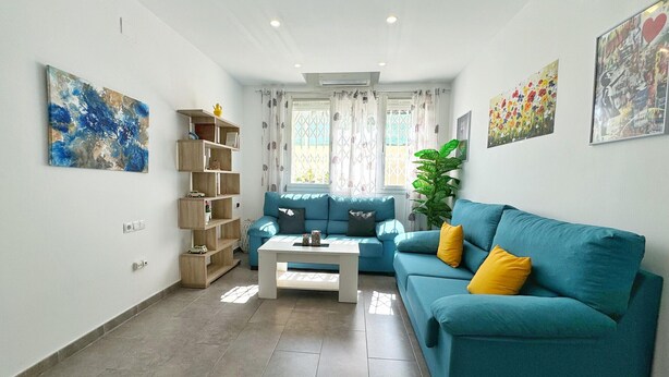 A living room with a sofa, a coffee table, and a bookshelf.