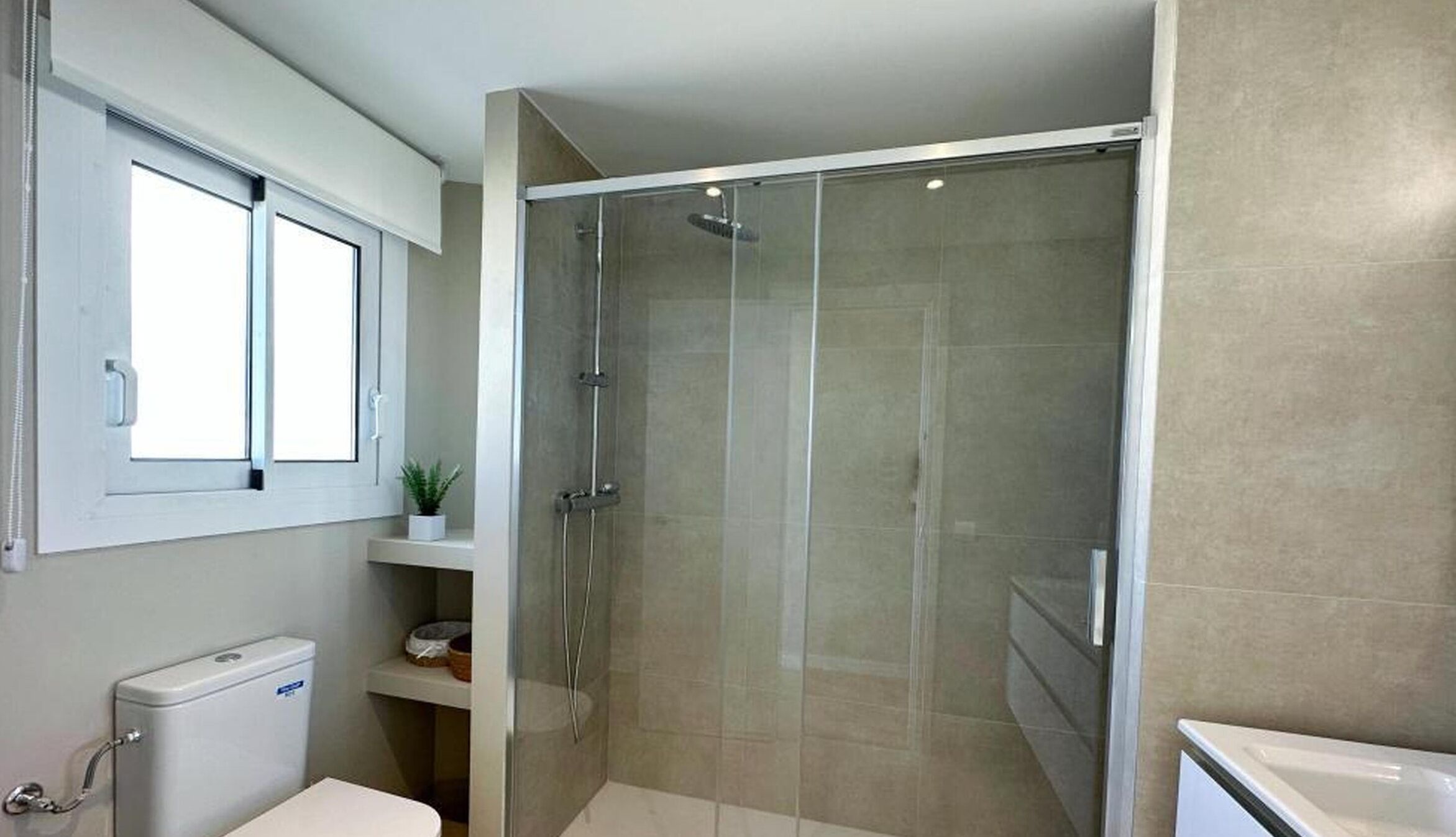 Ein modernes Badezimmer mit Duschkabine, Toilette und Waschbecken.