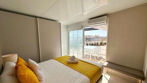 Ein Hotelzimmer mit Bett, Fenster und Blick nach außen.