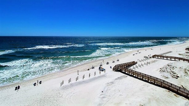 A beach with a wooden boardwalk and a sandy shore. - Lei Lani 607t (Orange Beach)