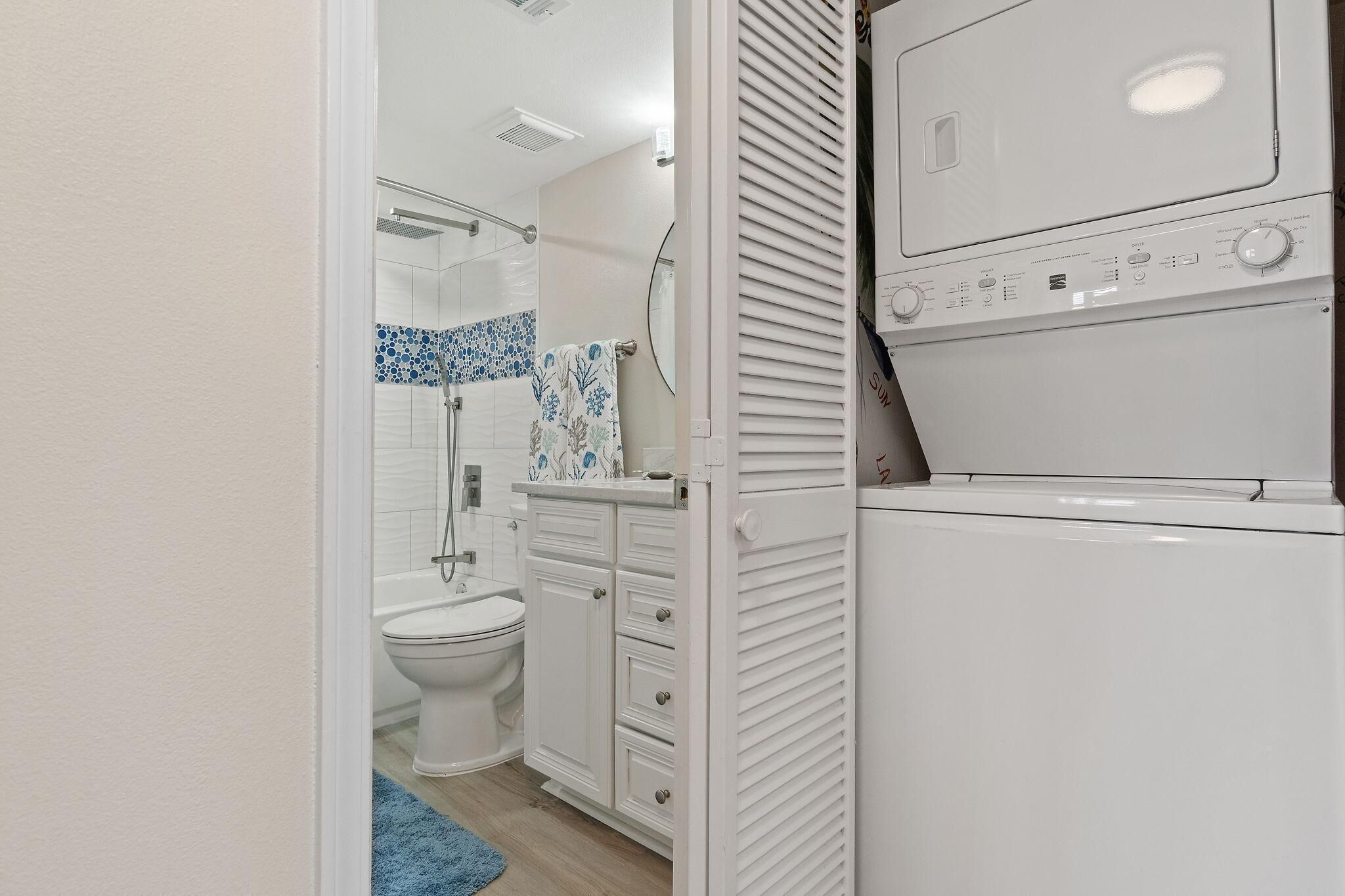 A compact bathroom with a toilet, a sink, and a washing machine.