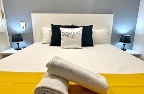 Relax in a serene space with a comfortable bed, two bedside tables, and lamps for a restful stay.