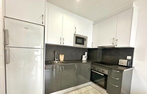 Modern kitchen with sleek cabinetry, stainless steel appliances, and an oven.