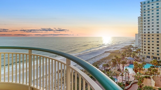 A high-rise hotel with a view of the beach and ocean at sunset. - Beach Colony West 9D (Pensacola)