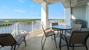 Ein Balkon mit Blick auf einen Yachthafen und einem Grill.