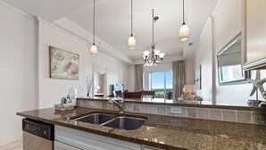 Eine moderne Küche mit Granit Arbeitsplatten, einer Spüle und einem Geschirrspüler. Ein Essbereich mit Blick ins Freie.