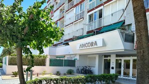 Un edificio a più piani con balconi e un cartello con la scritta 'ANCORA'.