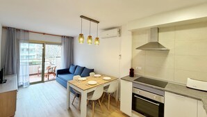 A modern kitchen with a built-in oven and a dining area with a table and chairs.