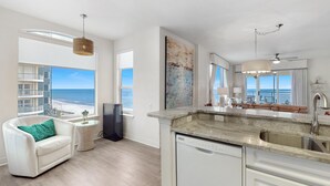 A modern kitchen with a large island, a built-in dishwasher, and a view of the ocean. - Beach Colony West 7A (Pensacola)