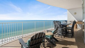 Un balcon avec vue sur l’océan, des meubles d’extérieur et un espace barbecue.
