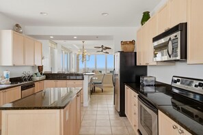 A modern kitchen with a central island, a built-in oven, and a microwave.