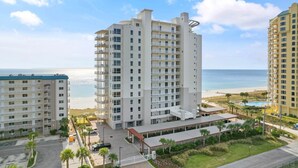 A high-rise hotel with multiple balconies, a pool area, and a view of the beach. - La Playa 801 (Pensacola)