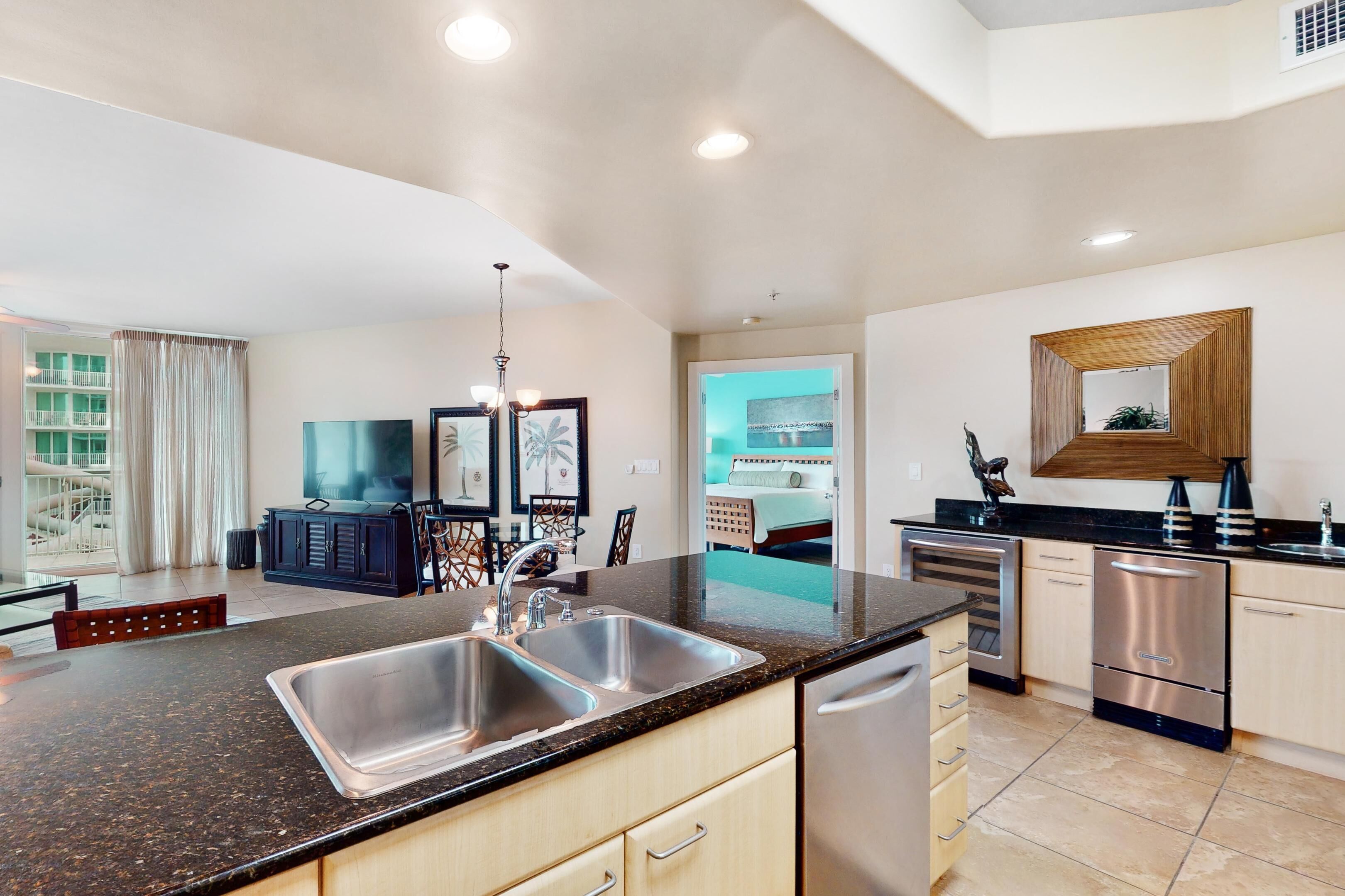 A modern kitchen with a granite countertop, stainless steel sink, and built-in appliances.