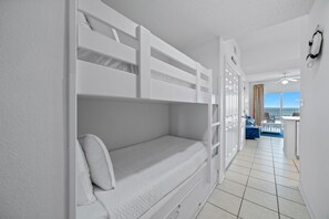 A room with a bunk bed, a desk, and a view of the sea. - Tidewater 503 (Orange Beach)