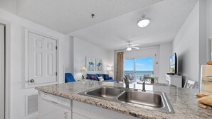A modern kitchen with granite countertops, a double sink, and a dishwasher. - Tidewater 503 (Orange Beach)