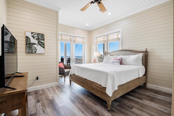A bedroom with a wooden bed, a television, and artwork on the wall.