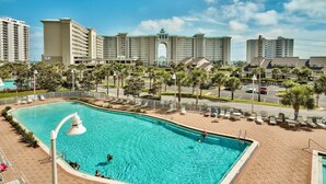 A hotel with a large pool, palm trees, and a view of other buildings. - Ariel Dunes I 2009 (Miramar Beach)