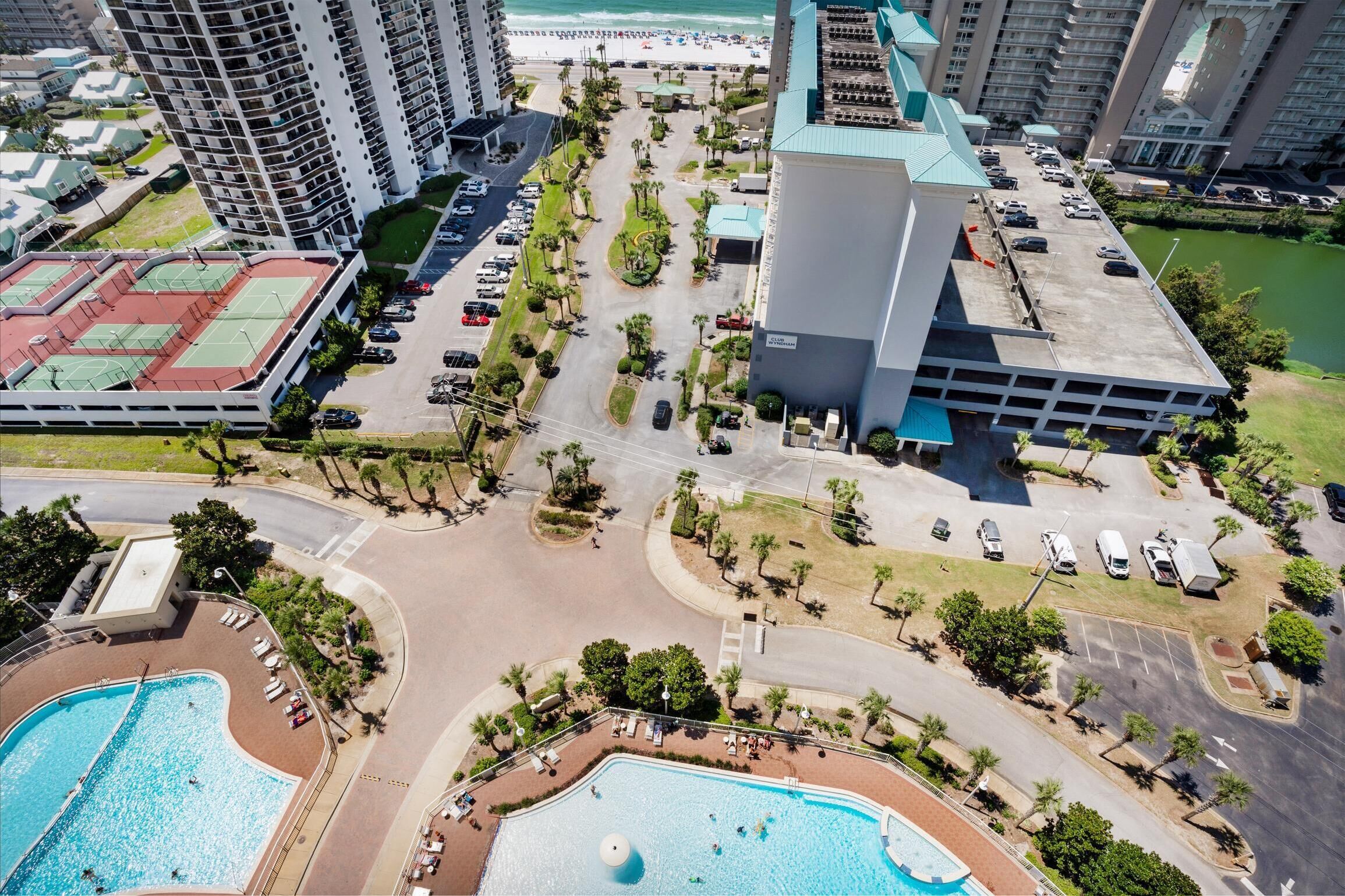 Un hôtel de grande hauteur doté de plusieurs piscines, d’un court de tennis et d’un parking.