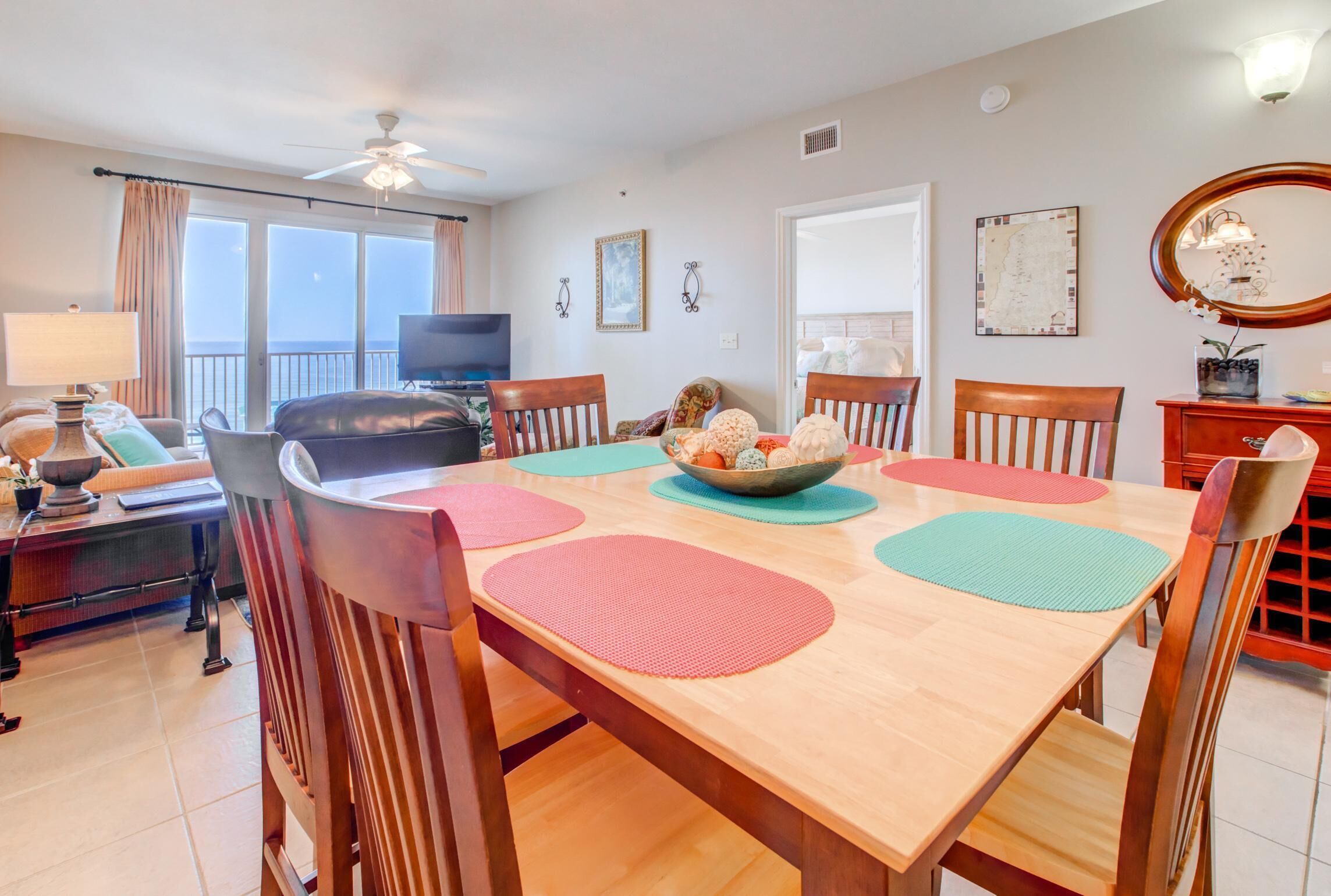 A dining area with a wooden table, chairs, and a television in the background.