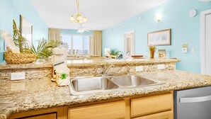 A kitchen with granite countertops, stainless steel sinks, and wooden cabinets. - Ariel Dunes I 1502 (Miramar Beach)