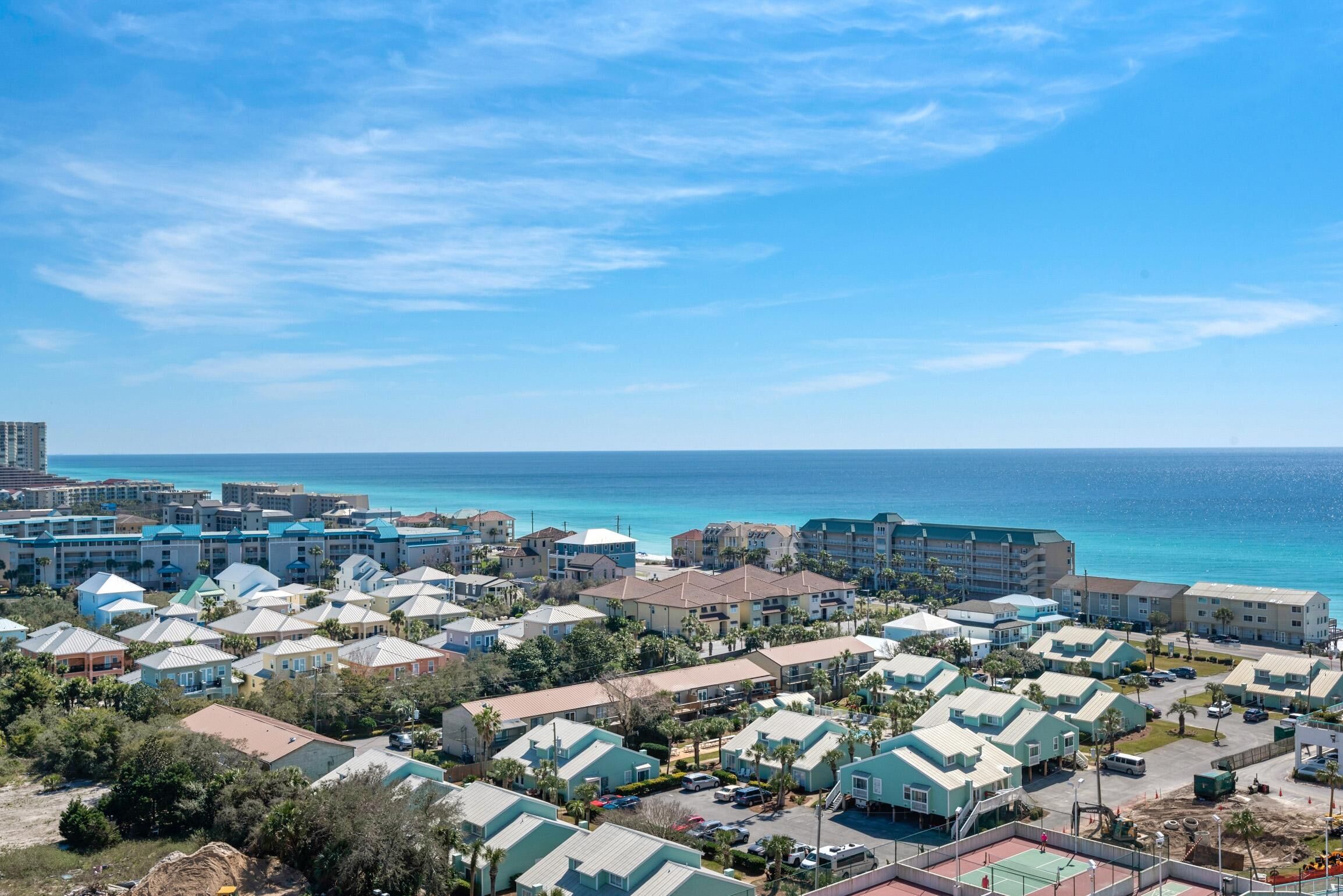 Una località balneare con diversi edifici a schiera e spiaggia, con vista diretta sull'oceano.