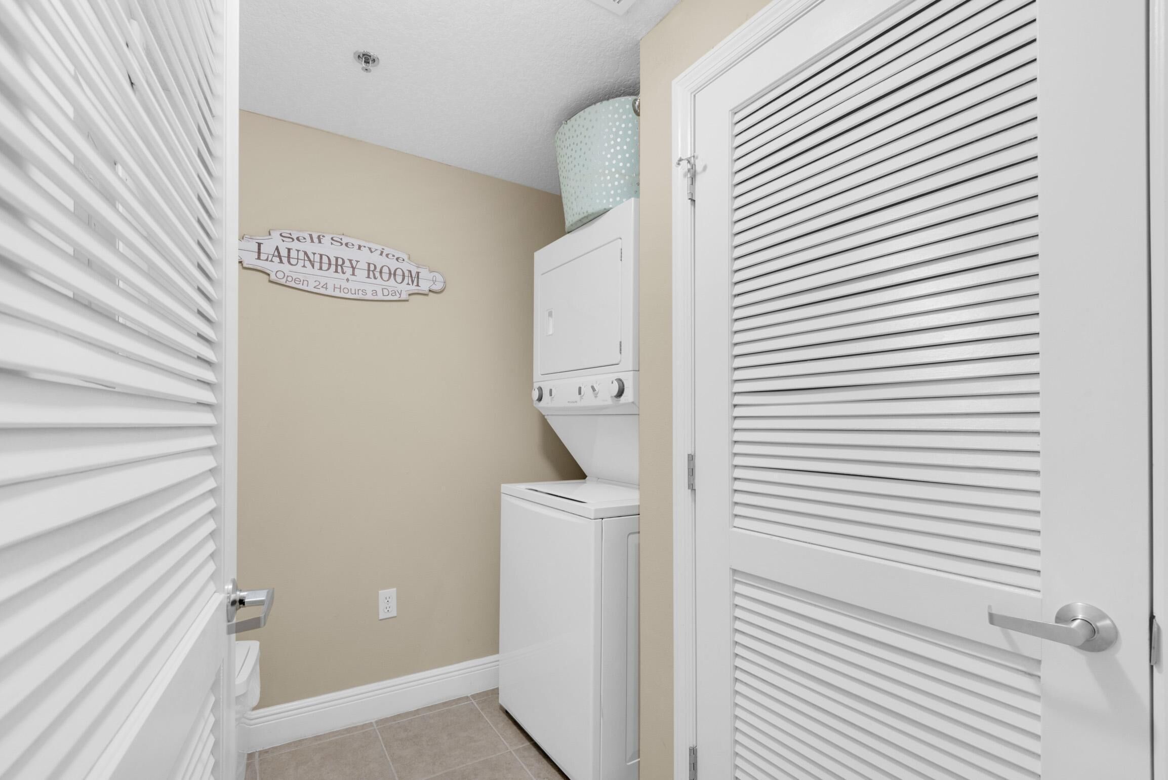 A laundry room with a sign indicating it's open 24 hours a day.