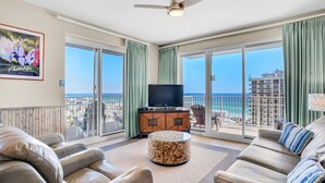 A spacious balcony with a view of the ocean, a flat-screen TV, and a comfortable seating area with a patterned ottoman. - Ariel Dunes I 1401 (Miramar Beach)