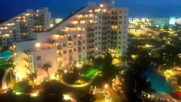 A multi-story hotel with balconies, a swimming pool, and landscaped gardens. - INTERNATIONAL dr/UNIVERSAL 2 Bedroom CONDO-HOTEL (Orlando)