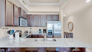 Una cocina con encimeras de granito, electrodomésticos de acero inoxidable y armarios de madera.