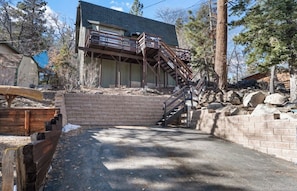 A two-story house with a wooden deck and a staircase leading to the upper level. - Ski slope views, Short walk to Bear Mtn and hiking trails. Great for all seasons (Big Bear Lake)