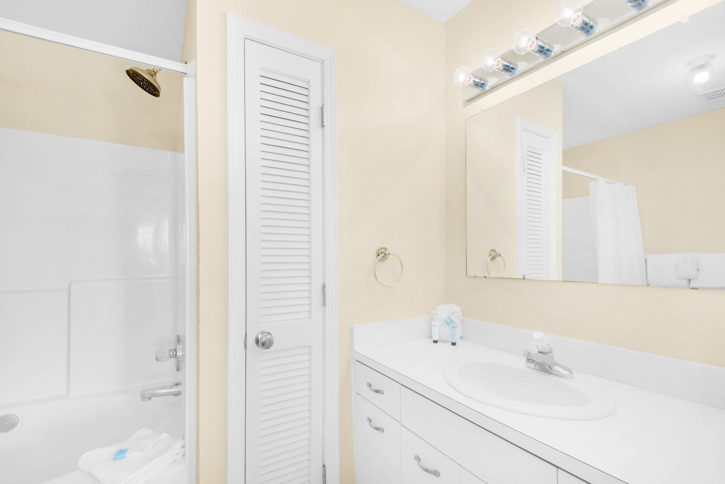 A bathroom with a shower, a sink, and a mirror.