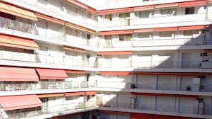 Un hôtel à plusieurs étages doté d’une cour intérieure où se trouve une piscine, le tout entouré de balcons avec des garde-corps.