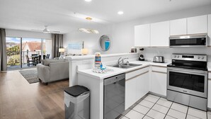A modern kitchen with white cabinets, a built-in oven, and a microwave. - Maravilla 1309 (Miramar Beach)