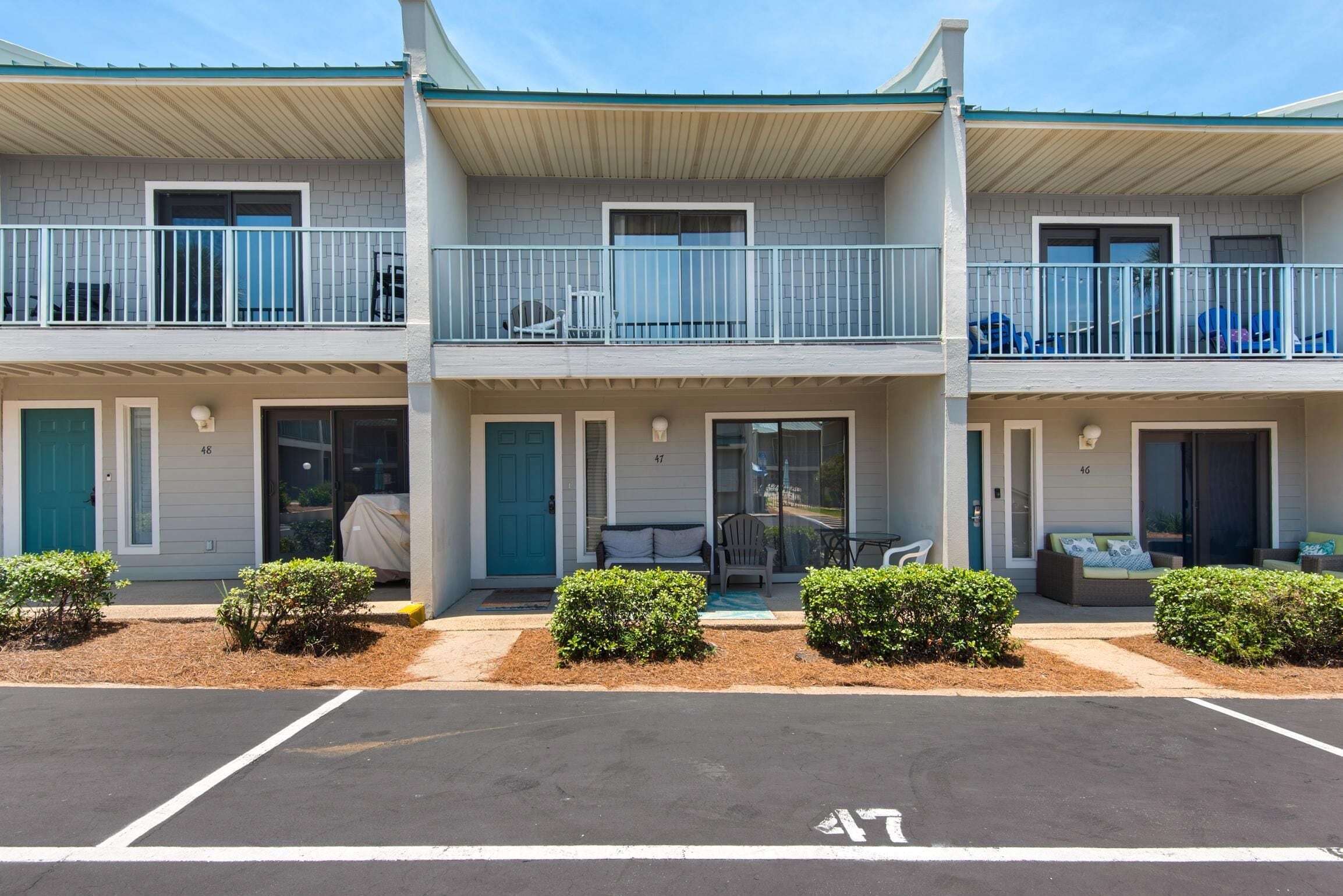 A two-story motel with a covered front porch, a small outdoor seating area, and a parking lot.