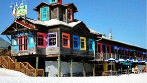 A wooden building with colorful windows and a signboard. - Gulfview II 306 (Miramar Beach)