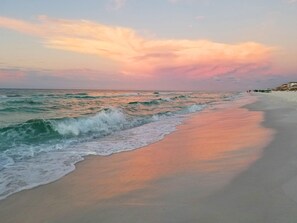 A beach with waves, a clear sky, and a distant shoreline with buildings. - Gulfview II 306 (Miramar Beach)