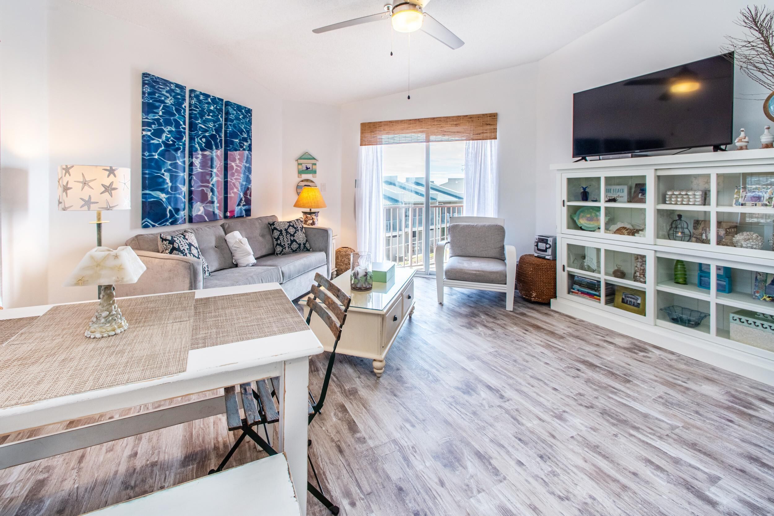 A modern living room with a dining area, a television, and a bookshelf.