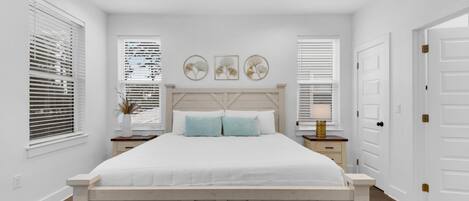 A bedroom with a bed, a ceiling fan, and two bedside tables with lamps.