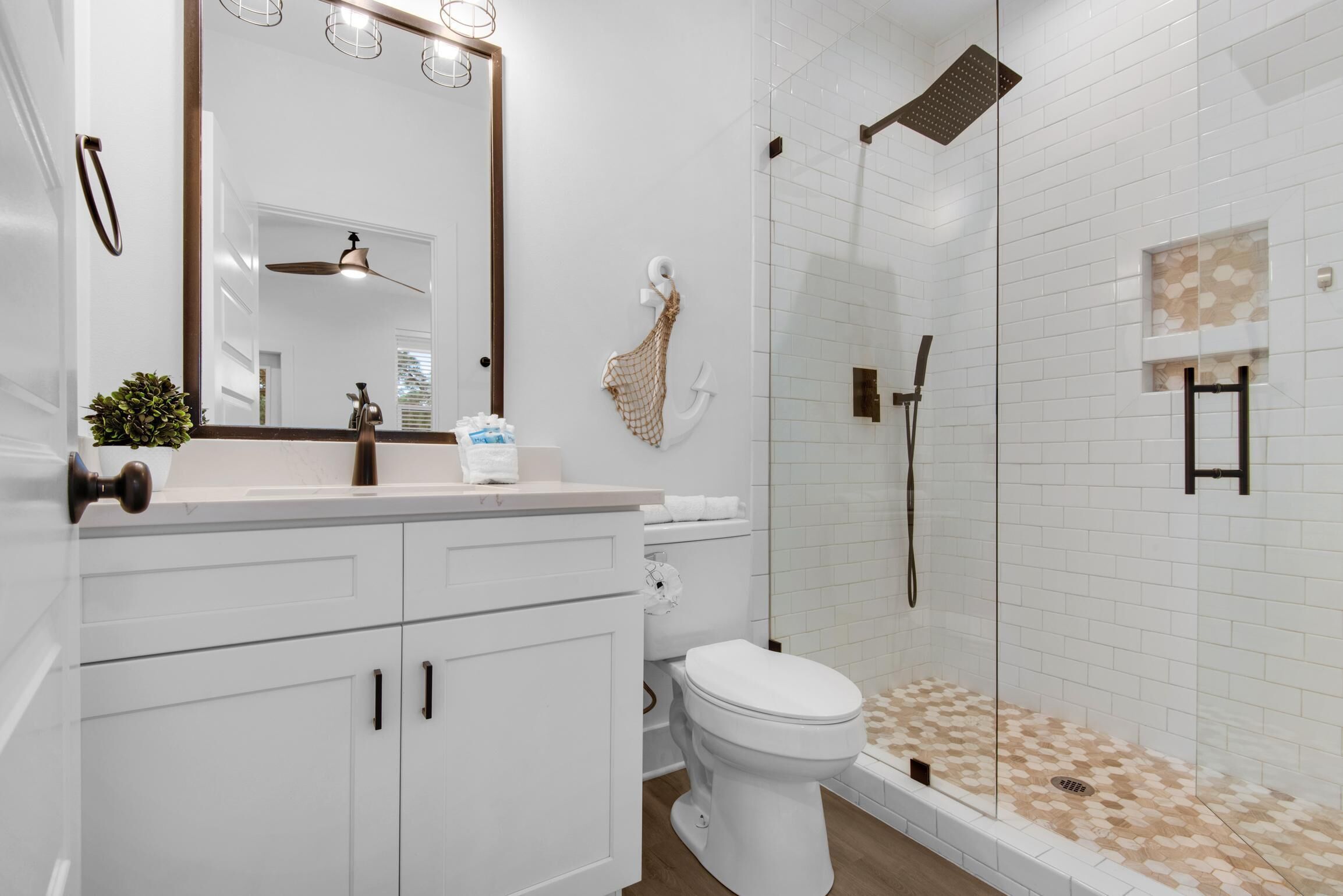 A modern bathroom with a white sink, toilet, and shower area.