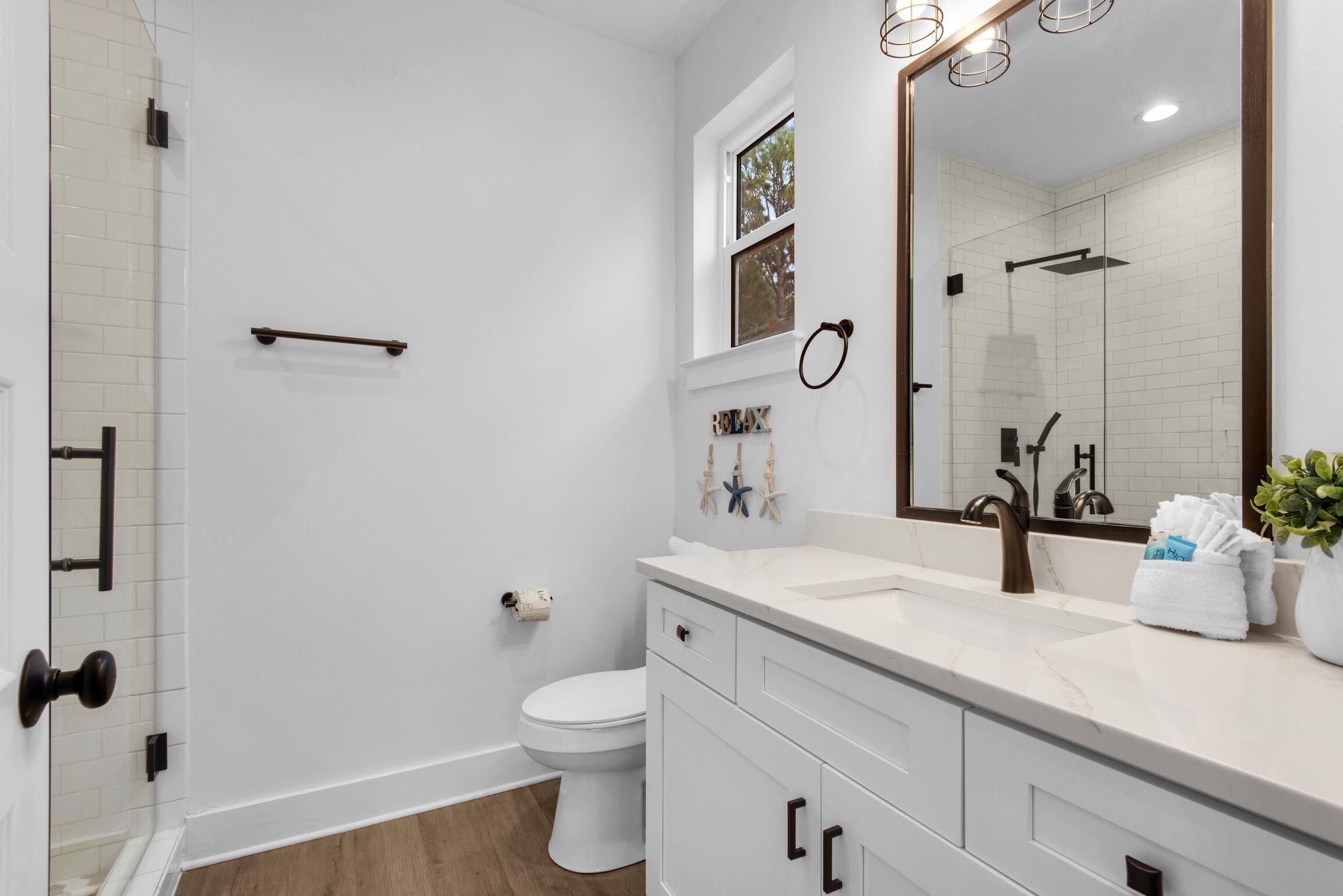 A modern bathroom with a shower, toilet, and vanity.